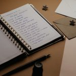 A tidy desk setup featuring a planner, to-do list, envelopes, and a pen.